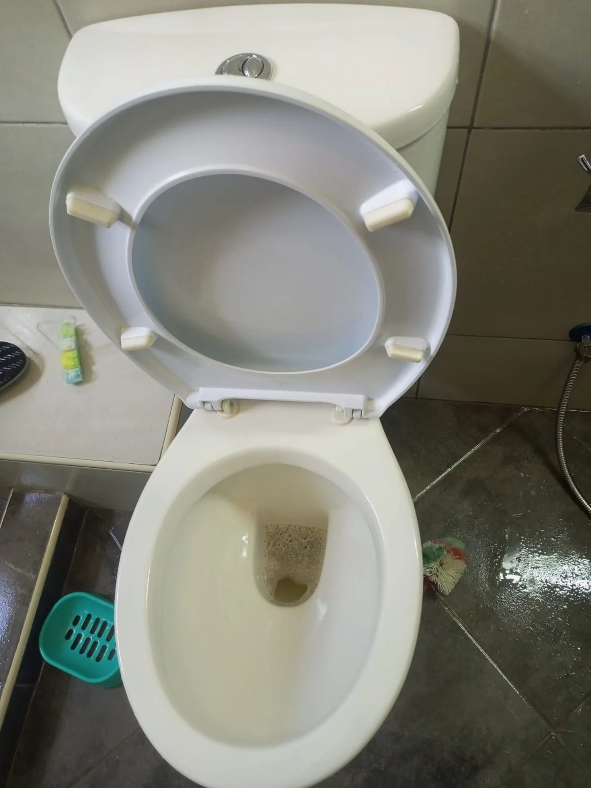 Toilet and tiled bathroom during cleaning