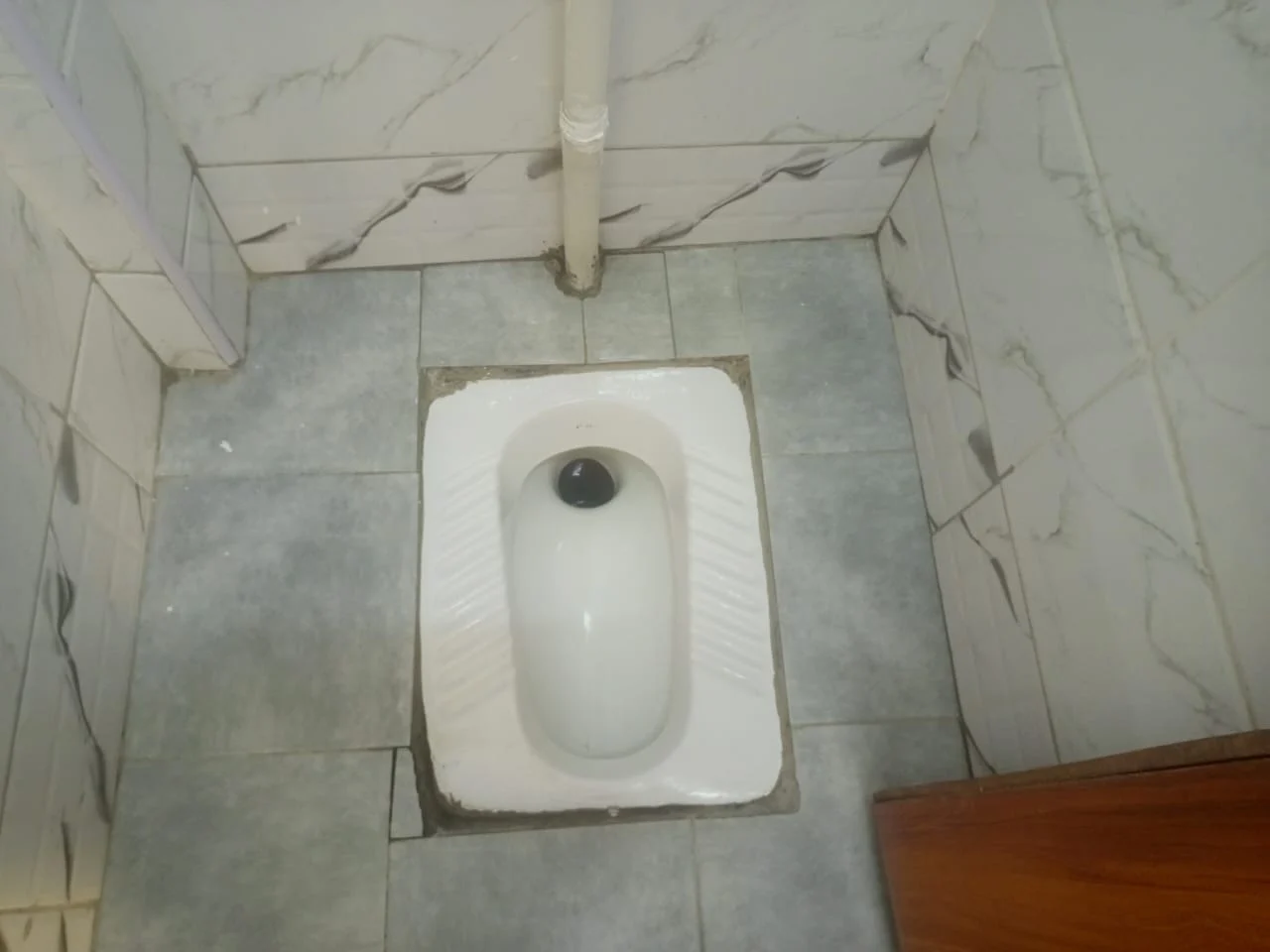 Squat toilet and tiled washroom floor